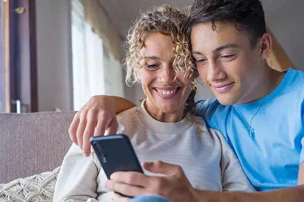 Smiling teenage boy hugging his mother in Agoura Hills, CA, illustrating the strong, supportive parent-child bond fostered through effective teen and family therapy changes