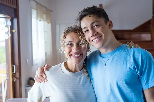 Smiling mother and teenage son in Westlake Village, CA, reflecting the stronger family bonds nurtured through teen therapy services in the area